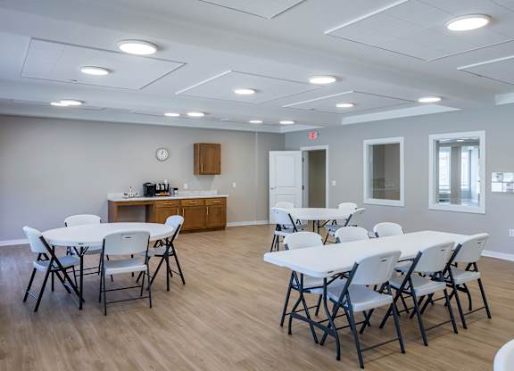 A white table with chairs is set up in a room with a wooden floor.