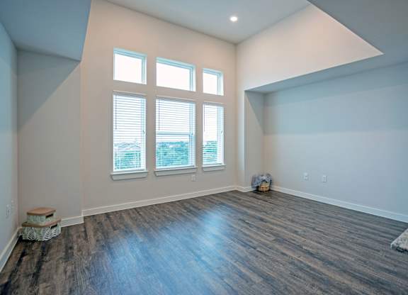 A room with a large window and wooden flooring.