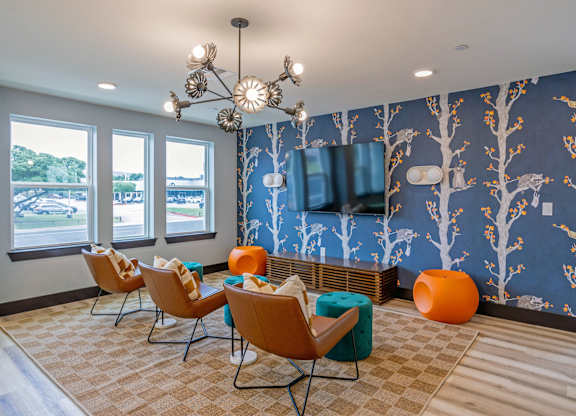 A room with a blue wallpaper and a wall-mounted television.