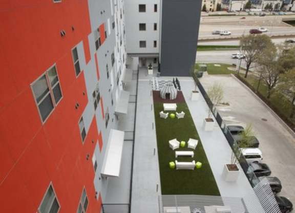 A red building with a green lawn in front.