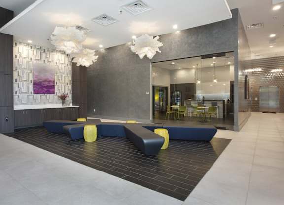 A modern lobby with a reception desk and a large abstract painting on the wall.