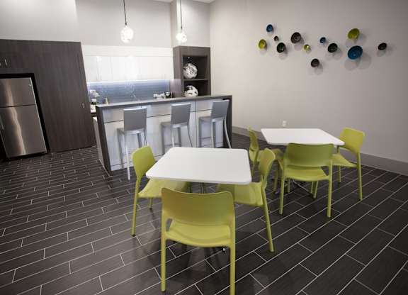 A kitchen with a table and chairs.