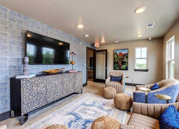 A living room with a patterned wall and a blue and white rug.