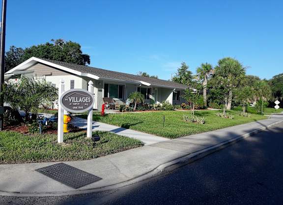 A sign for Villages at Peterson Park is on the corner of a street.