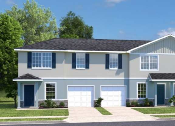 A large, two-story house with a grey and white exterior and multiple garages.