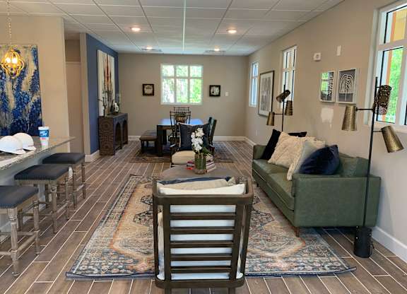 A living room with a green couch and a rug.