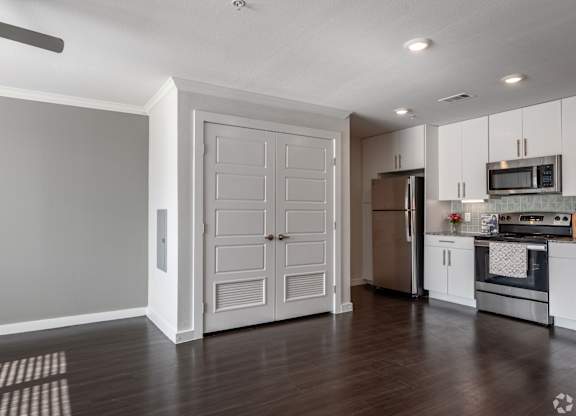 A kitchen with white cabinets and a refrigerator.