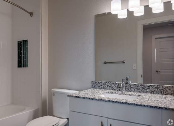 A white bathroom with a tub, toilet, and sink.