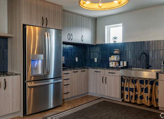 A modern kitchen with a stainless steel refrigerator and wooden cabinets.