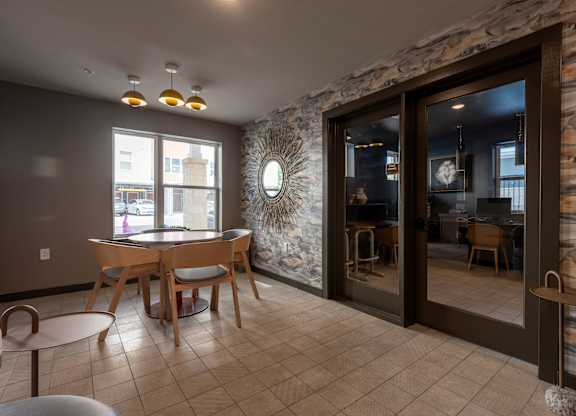 A room with a stone wall and a table with chairs.