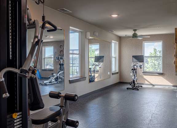A gym with a variety of equipment including a stationary bike and a treadmill.