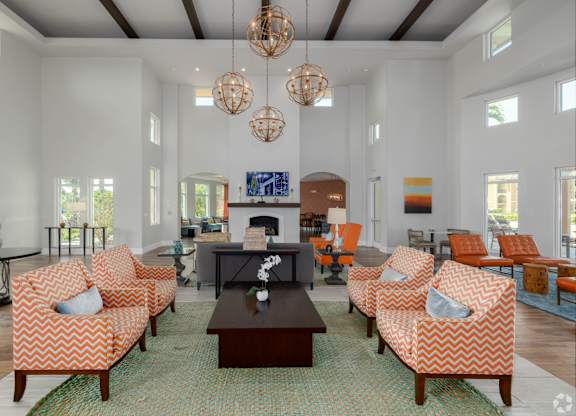 A living room with orange and white patterned chairs and a fireplace.