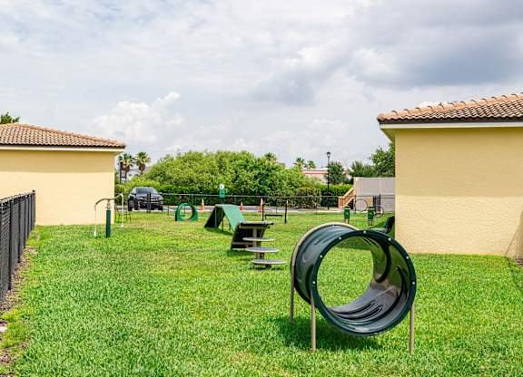 A playground with a green slide and picnic table.