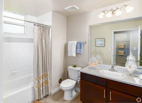 A white bathroom with a toilet, sink, and shower.