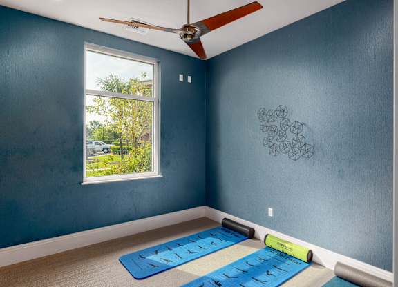 A room with blue walls and a ceiling fan.