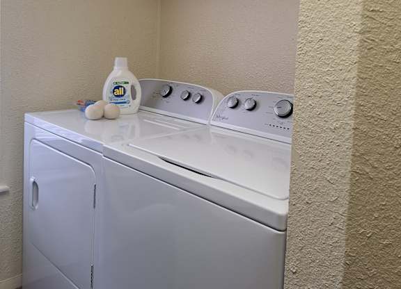 A white washing machine and dryer in a small laundry room.