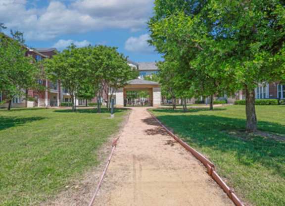 A pathway leads to a building in a park.