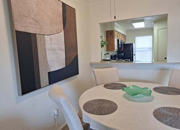 A modern dining room with a large abstract painting on the wall.