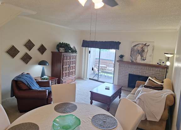 A living room with a fireplace and a dining table.