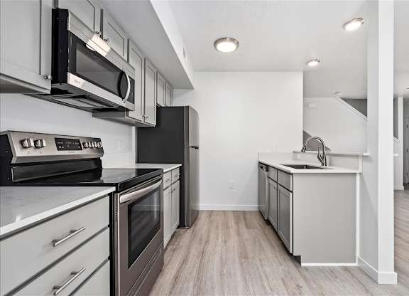 A modern kitchen with stainless steel appliances and white cabinets.