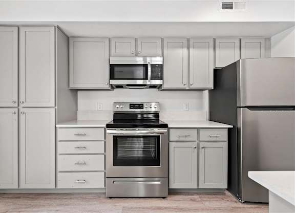 A modern kitchen with stainless steel appliances and white cabinetry.