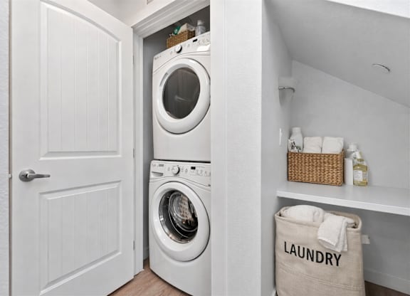 A white washing machine is in a small laundry room.