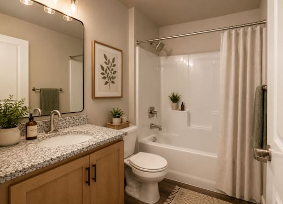 A bathroom with a toilet, sink, and shower.