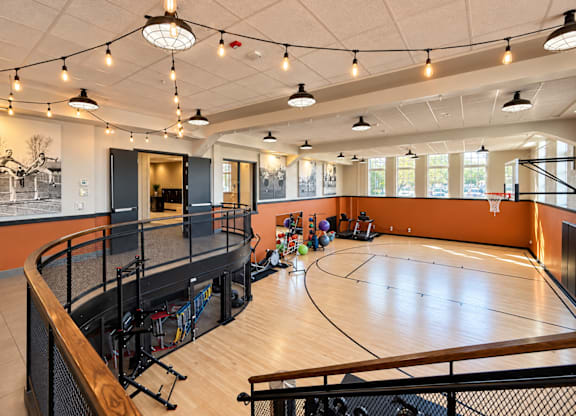 A basketball court inside a gym with a basketball hoop and a net.
