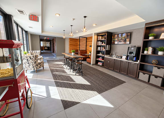 A red food cart is in the foreground of a modern lobby area.