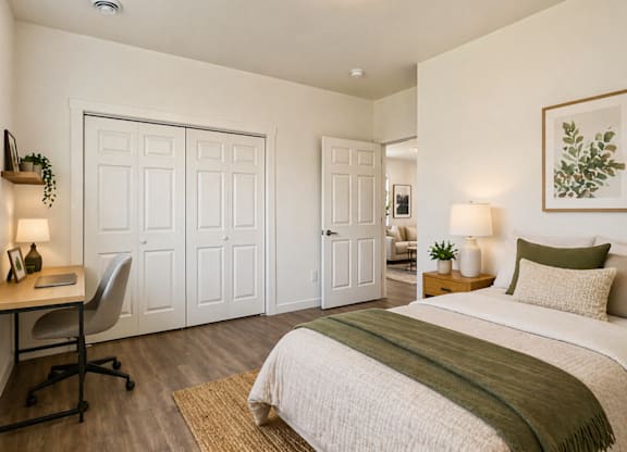 A bedroom with a bed, desk, and chair.