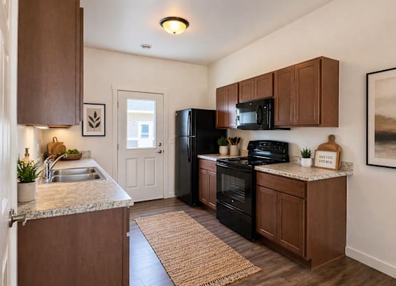 A kitchen with brown cabinets and black appliances.