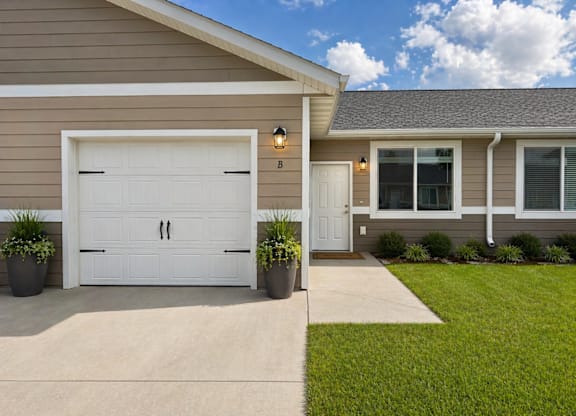 A house with a white garage door and a small porch.