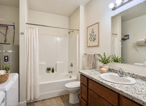 A white bathroom with a toilet, sink, and bathtub.