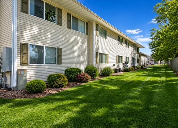 A row of houses with green lawns in front.