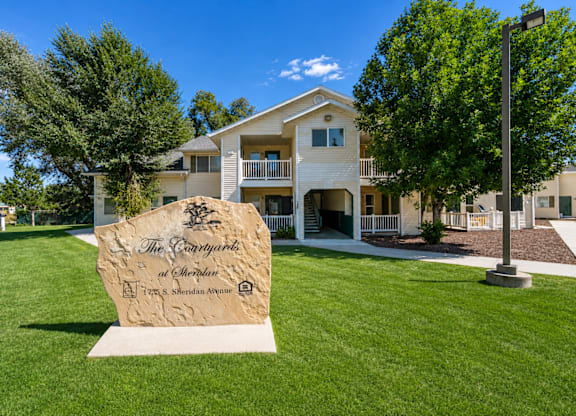 A large stone sign in front of a building that says "The Parkway".