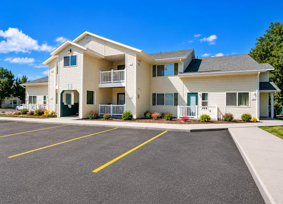 A large two-story building with a parking lot in front.