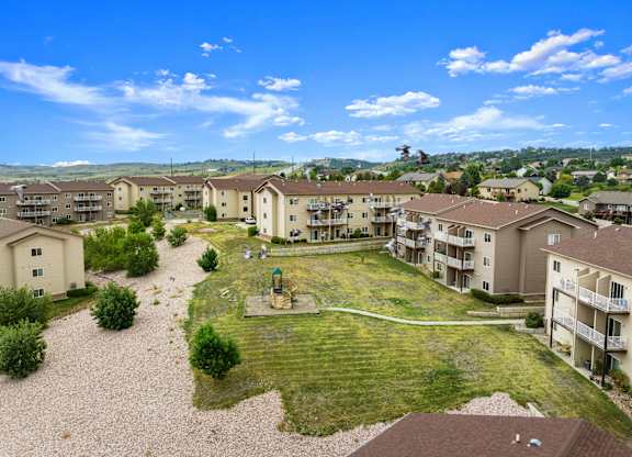 A sunny day at a residential complex with apartments and a playground.