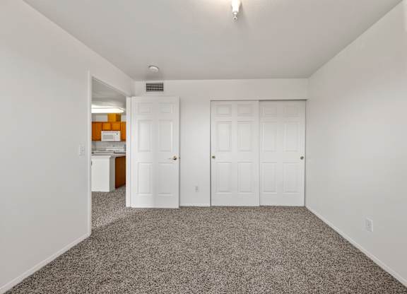 A room with a grey carpet and white walls.