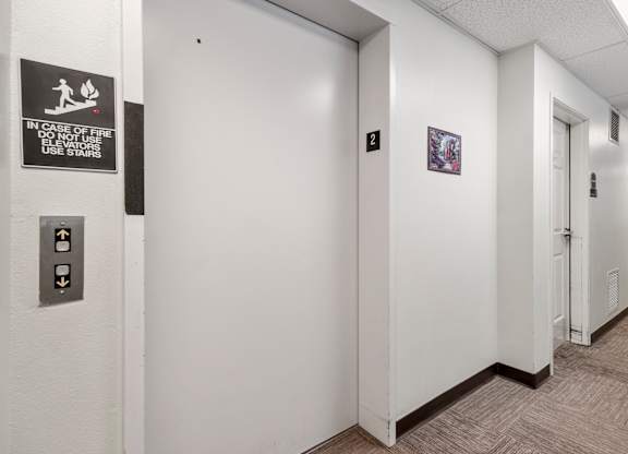 A hallway with a sign on the wall that says "In case of fire do not use stairs".