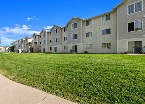 Apartment complex with green grass in front.