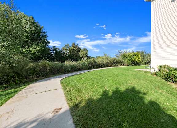 A concrete pathway leads through a grassy area.