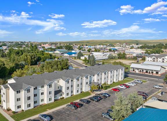 A large white building with a parking lot in front of it.