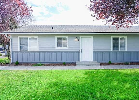 A house with a grey siding and a white door.