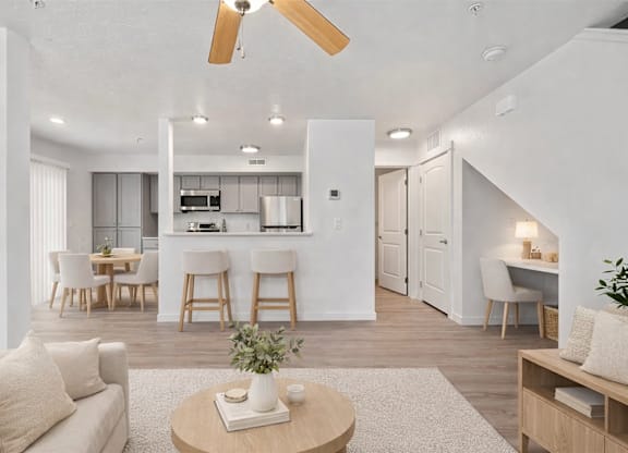 A living room with a white couch, a wooden coffee table, and a ceiling fan.
