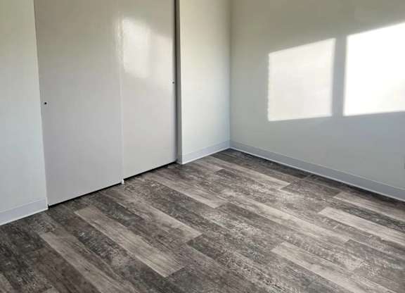 A room with a ceiling fan and a wooden floor.