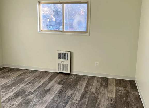 A room with a window and a fan on the ceiling.
