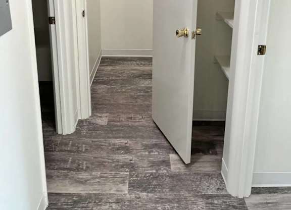 A hallway with a white door and a grey carpet.