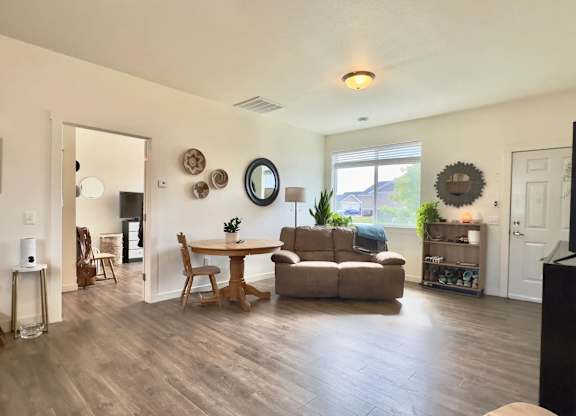 A living room with a wooden floor and furniture.