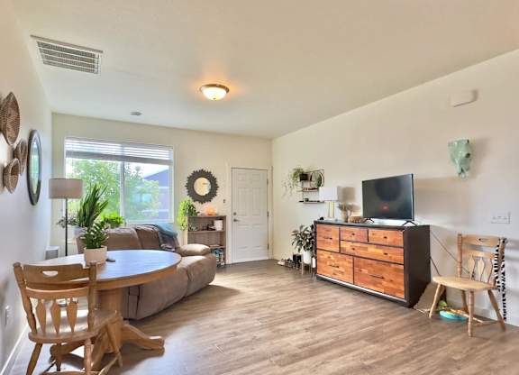 A living room with a couch, a table, and a television.