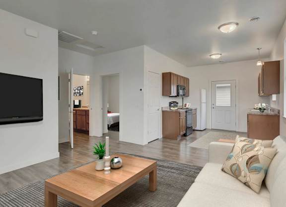 A modern living room with a wooden coffee table and a large flat screen TV.